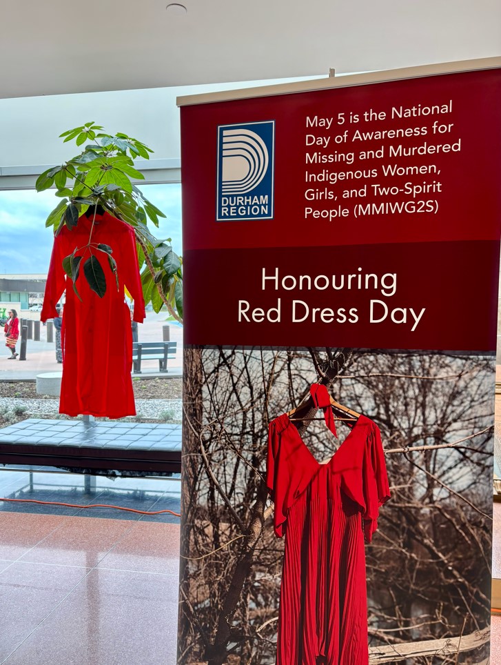 A red dress hanging in the window at Regional Headquarters